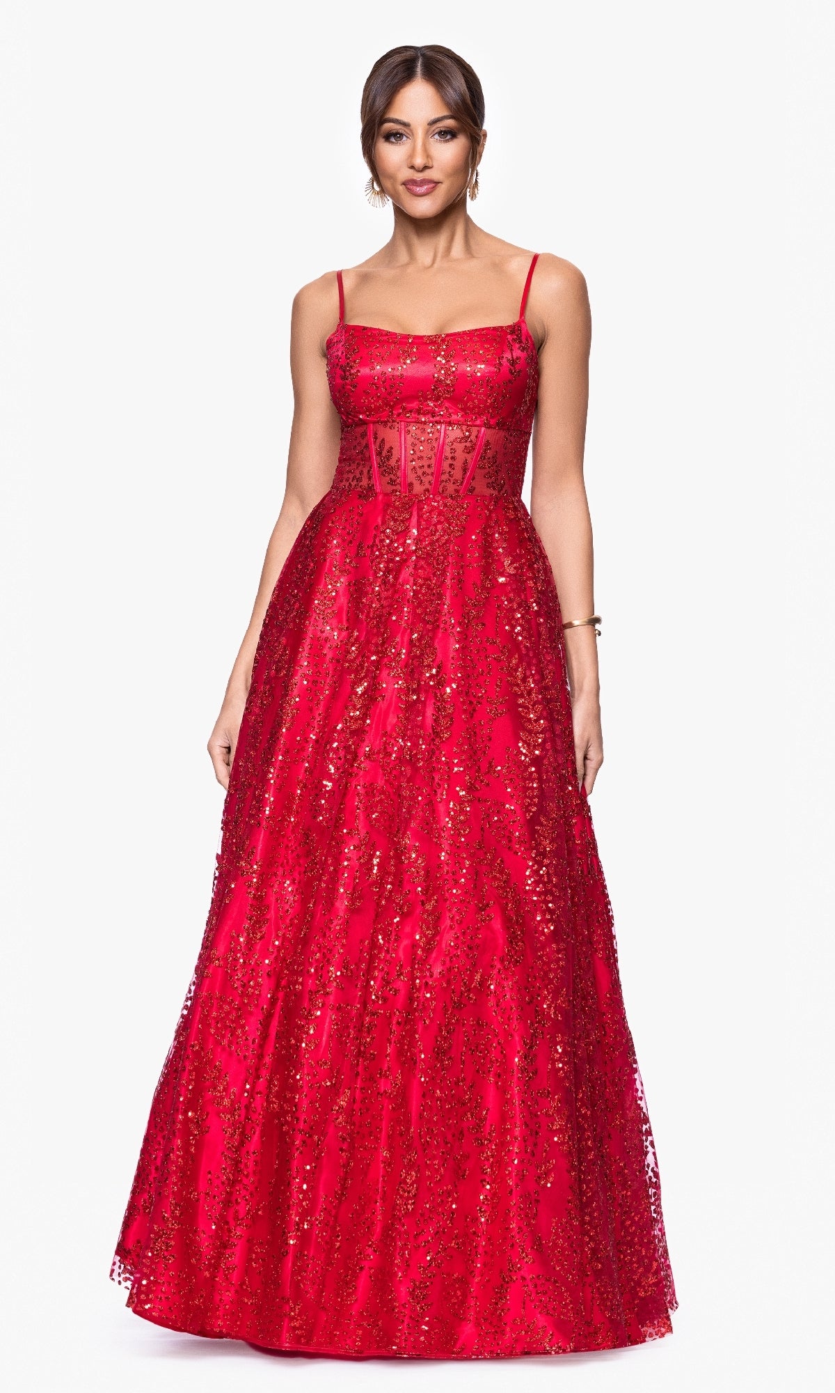 A woman wears the Blondie Nites 5539BN Glitter-Print Prom Ball Gown, a sleeveless, floor-length formal dress with sequins and a sheer panel corset bodice, standing against a plain white background.